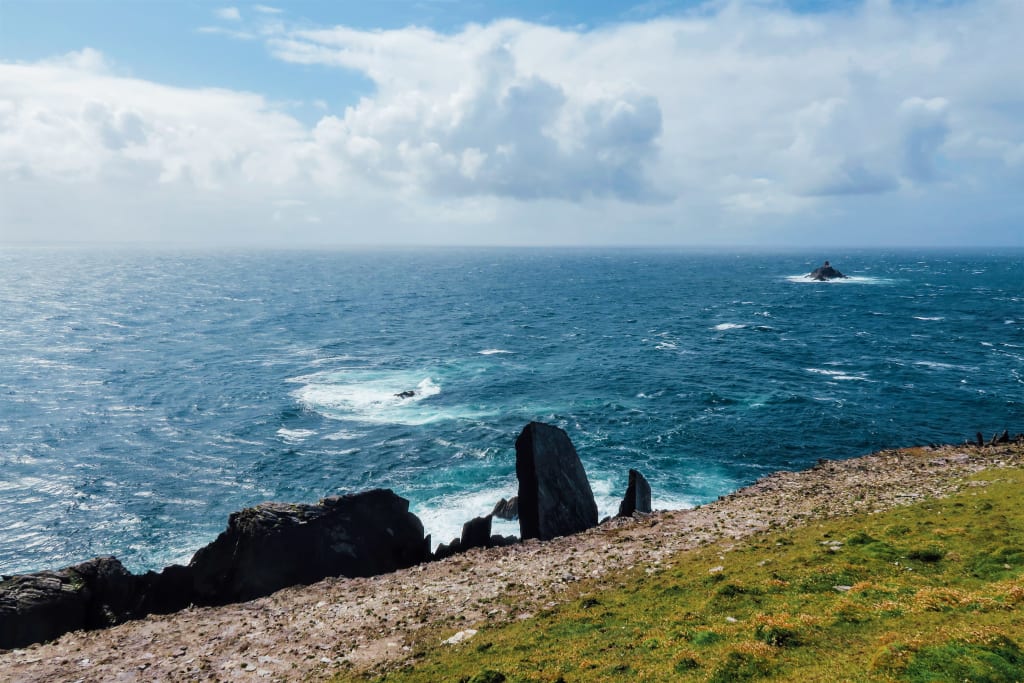 Costa scoscesa con vista sull'oceano e prati verdi lungo la Kerry Way.